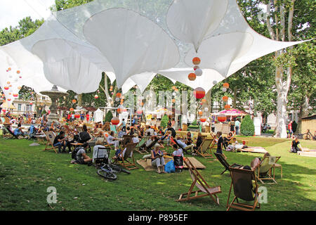 ZAGREB, CROATIE - Juillet 7th, 2018:ouverture du Festival dans le parc Zrinjevac Ville quand de nombreuses personnes avec des livres de lecture et des boissons en Zrinjevac Banque D'Images