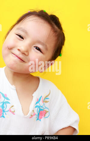 A quatre ans, petite fille asiatique grimaça à l'appareil photo Banque D'Images