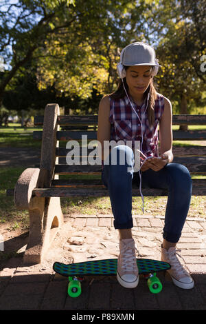 Woman listening to music in the park Banque D'Images