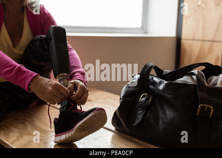 Attacher ses lacets femme dans la salle de sport Banque D'Images