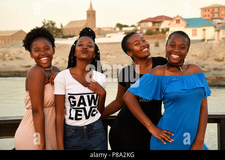Quatre jeunes femmes noires qui pose au bord de l'eau, Lüderitz, Namibie Banque D'Images