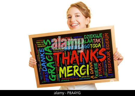 Jeune femme avec message de remerciement sur un tableau en plusieurs langues Banque D'Images