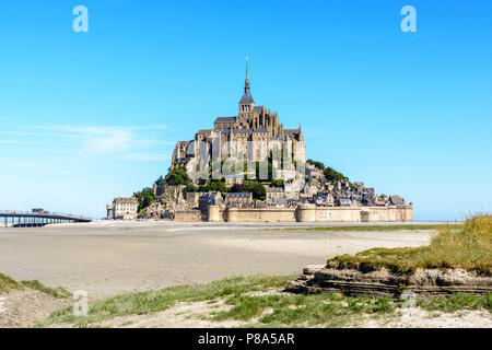Vue générale du Mont Saint-Michel île intertidale de la baie à marée basse sous un ciel bleu d'été. Banque D'Images