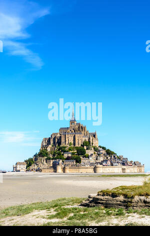 Vue générale du Mont Saint-Michel île intertidale de la baie à marée basse sous un ciel bleu d'été. Banque D'Images