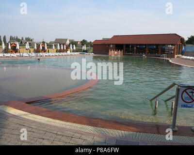 Piscine déserte avec de l'eau claire et claire debout sur le côté opposé de chaises longues et parasols pliés contre le soleil. . Pour votre conception Banque D'Images