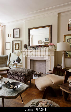 Un original Papa Bear lounge chair conçu par Hans Wegner dans coin de salon avec Leopard print table mosaïque ottomans et italiens Banque D'Images