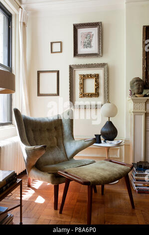 Un original Papa Bear lounge chair conçu par Hans Wegner en salle avec des cadres décoratifs sur le mur. Banque D'Images