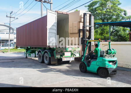 Le travailleur avec un chariot élévateur de palettes de chargement dans un camion. Banque D'Images