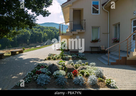 Beaux parterres de fleurs sur une chaussée pavée près de l'escalier d'une maison propre . Pour votre conception Banque D'Images