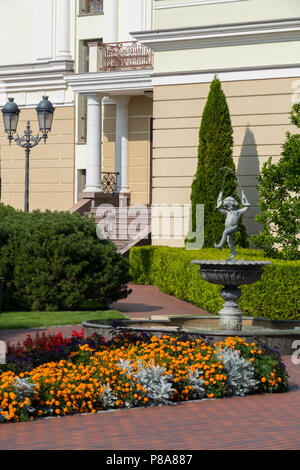 Hôtel particulier de couleurs claires avec des lits de fleurs, pyramidale thuys, une fontaine avec une statue d'un garçon et de belles lanternes. lieu de repos . Pour vous Banque D'Images