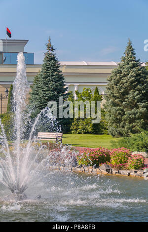 Fortement ébranlée fontaine au milieu d'un processus transparent zera contre l'arrière-plan de petits lits de fleurs et arbres verts . Pour votre conception Banque D'Images