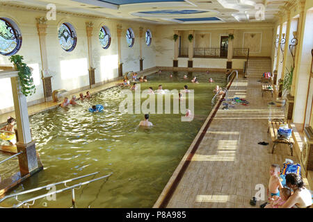 Une piscine dans un bâtiment avec les clients et les gens de la natation. Avec un bel intérieur à l'intérieur les lampes sur les murs, des moulures en stuc au plafond Banque D'Images