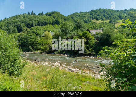 Des pierres éparpillées le long d'une rivière peu profonde avec des maisons sur ses rives . Pour votre conception Banque D'Images