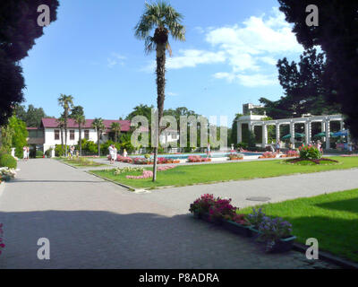 Allée couverte de plexus de pierres naturelles entre les parterres colorés. Et d'un seul palmier au milieu . Pour votre conception Banque D'Images