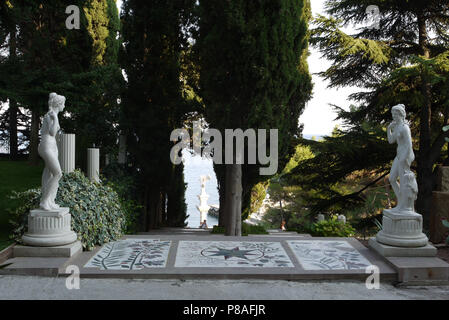 L'allée ressemble à un couloir avec de grands arbres de chaque côté et deux statues blanches de la femme à l'entrée de c . Pour votre conception Banque D'Images