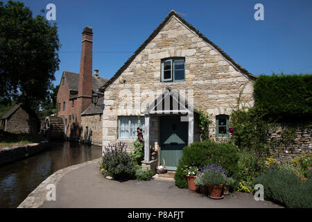 Lower Slaughter dans les Cotswolds, Royaume-Uni. Lower Slaughter village est construit sur les deux rives de l'Œil, un flux lent, traversé par deux passerelles. À l'extrémité ouest du village il y a un 19ème siècle moulin à eau avec une roue hydraulique de l'undershot et une cheminée pour obtenir de la vapeur. Alors que l'usine est construite en briques rouges la plupart des 16ème et 17ème siècle dans le village en pierre de Cotswold utiliser. Le nom du village provient du vieux terme anglais "lough signifiant terre humide'. La région des Cotswolds est une zone dans le centre sud de l'Angleterre. La zone est définie par le substratum de calcaire Banque D'Images