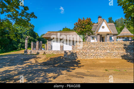 Un petit, belle maison avec un toit de roseau entouré d'une clôture en pierre au milieu de la forêt . Pour votre conception Banque D'Images