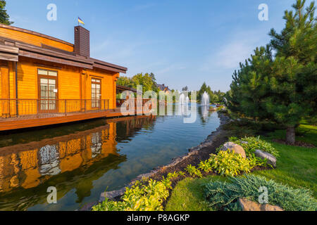 Une maison en bois est situé au-dessus du lac avec des fontaines dans le parc. mezhigriya l'Ukraine . Pour votre conception Banque D'Images