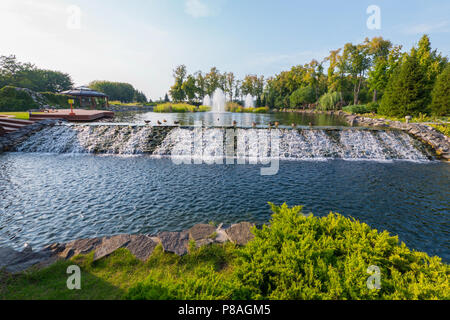 Une cascade artificielle d'un lac dans le parc à proximité d'un gazebo en bois avec une terrasse. Petrivtsi Novi, l'Ukraine . Pour votre conception Banque D'Images