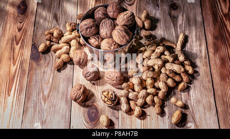 Les noix et arachides sur une table en bois. La lumière naturelle à partir de la fenêtre Banque D'Images