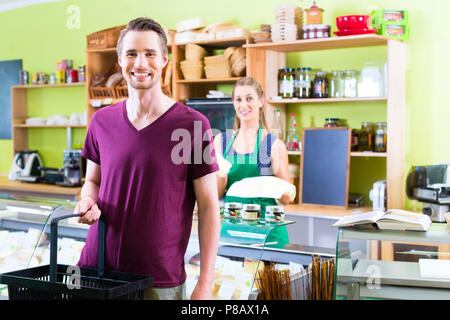 Vendeuse au comptoir fromage offrant Banque D'Images