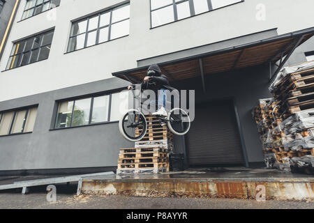 Low angle view of young bmx biker jumping on street Banque D'Images