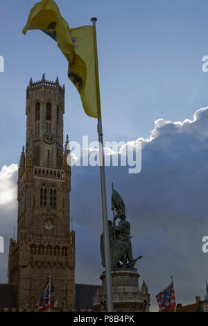 Le planeur Belfort gothique, ou tour du beffroi de l'Hallen dans le Markt, Bruges, Belgique, avec drapeaux et statue Banque D'Images