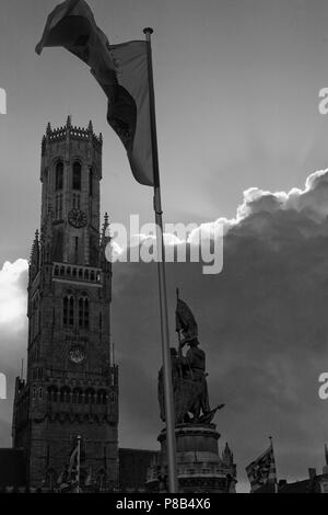 Le planeur Belfort gothique, ou tour du beffroi de l'Hallen dans le Markt, Bruges, Belgique, avec drapeaux et statue. Version noir et blanc Banque D'Images