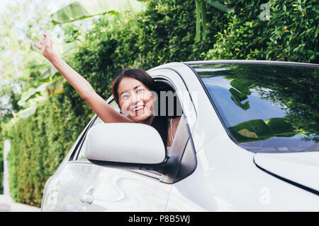 Young Happy Asian woman smiling and waving from siège du conducteur dans la voiture tout en prenant sur les voyages Voyage Banque D'Images