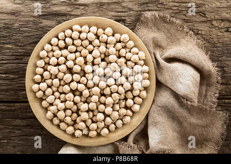 Pois chiches crus ou garbanzo (lat. Cicer arietinum) sur plaque de bois, photographié dans le ciel en bois rustique (Selective Focus, Focus sur les pois chiches) Banque D'Images