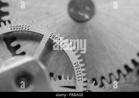 Arrière-plan avec l'inscription de succès. Black metal fond blanc avec des rouages des roulettes. Macro. Photo conceptuelle pour votre entreprise avec succès Banque D'Images