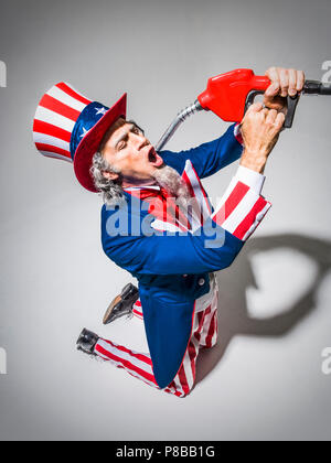 L'Oncle Sam à genoux avec une buse de la pompe à gaz qui a eu lieu en face de sa bouche comme s'il allait boire de l'essence. Shot conceptuel illustrant l'American addict Banque D'Images