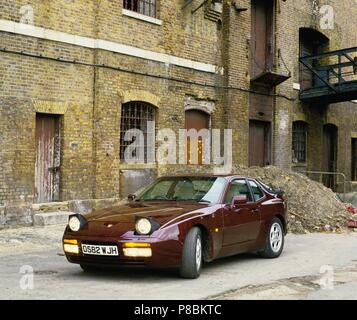 Porsche 944 Turbo - année modèle 1986 de couleur métallique brun acajou - Vues avant et latérale en milieu industriel Banque D'Images