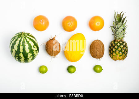 Modèle des fruits colorés de l'ananas, pastèque, noix de coco, pamplemousse, citron vert et melon sur fond blanc. Vue d'en haut. Mise à plat. Fond d'été Banque D'Images