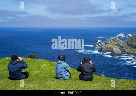 Les ornithologues amateurs regarder littoral avec des falaises et des piles, accueil à l'élevage des oiseaux de mer à Hermaness, Unst, Shetland, Scotland, UK Banque D'Images