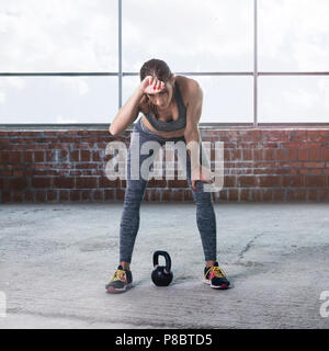 Athlète femme se reposant après l'entraînement avec haltères. Copier l'espace. Concept de remise en forme Banque D'Images