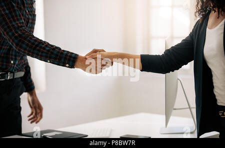 Close up of business partners shaking hand. Message d'homme d'une femme entrepreneur à sa table de bureau. Banque D'Images