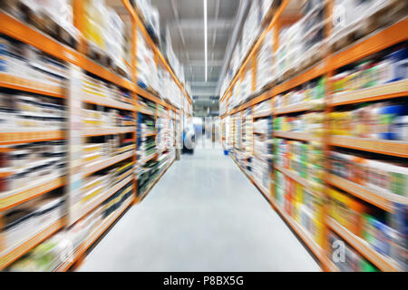 La construction matérielle de l'allée de supermarché et des étagères. Vue en perspective des lignes d'hypermarchés avec des produits. Résumé floue et d'échange commercial background Banque D'Images