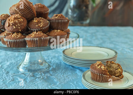 Affichage des muffins banane noix sur le plateau, avec des demi-mangé un sur une assiette de service. Banque D'Images