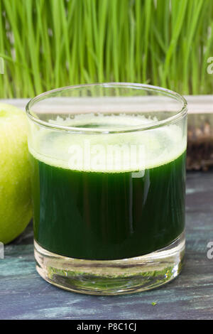 Verre de jus fraîchement pressés d'herbe de blé et de pomme verte Banque D'Images