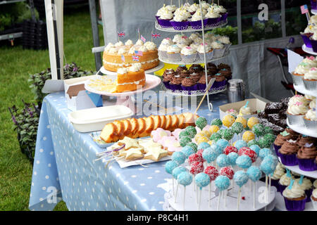 Variété de fantaisie cupcakes, sucettes et autres gâteaux sur l'affichage sur un étal du marché Banque D'Images