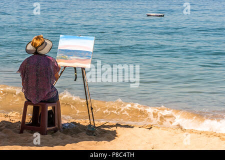 PUERTO VALLARTA, MEXIQUE - Mars 13, 2018 : une femme non identifiée artiste peint une scène de bord de mer, en mars 2018, sur la plage de Los Muertos, MX-JAL. Banque D'Images