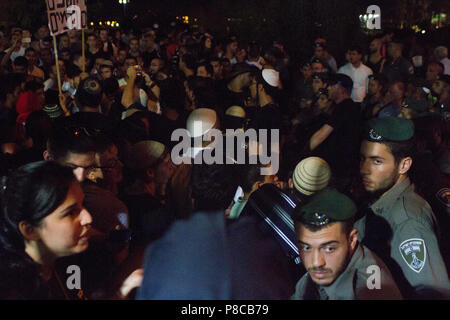 Regarder sur la police alors que les manifestants d'Israël des slogans anti-musulmans chant au mariage d'une dame juive et un musulman. Banque D'Images