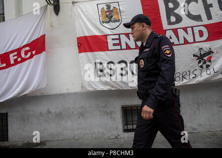 Moscou, Russie. 10thJuly, 2018. Un policier russe sur fond de drapeaux de l'Angleterre à la rue Nikolskaïa de Moscou avant la Croatie contre. L'Angleterre en demi-finale de la Coupe du Monde 2018, la Russie Crédit : Nikolay Vinokourov/Alamy Live News Banque D'Images