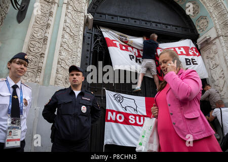 Moscou, Russie. 10thJuly, 2018. La police russe a l'air comment accrocher des fans de football anglais de l'Angleterre les drapeaux sur un immeuble sur la rue Nikolskaïa avant le match de l'Angleterre contre la Croatie de la Coupe du Monde FIFA 2018 Russie Crédit : Nikolay Vinokourov/Alamy Live News Banque D'Images