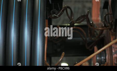 Bobine d'enfilage rouleau tuyau. Fabrication de tuyaux d'eau en plastique usine. Procédé de fabrication de tubes en plastique sur la machine-outil avec l'utilisation de l'eau et la pression de l'air. Banque D'Images