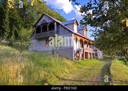 Maison de deux étages avec balcon sculpté et porche dans le village . Pour votre conception Banque D'Images