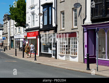 Couple en train de marcher le long de la rue principale, Dalton, Cumbria, Angleterre, Royaume-Uni Banque D'Images