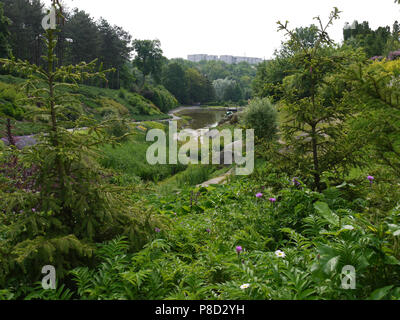 Une rivière en vert plantations sur l'arrière-plan des bâtiments de la ville dans le parc dendrologique . Pour votre conception Banque D'Images