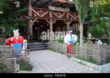 Entrée au restaurant avec des héros des contes de fées debout devant lui dans les vêtements avec une barrière et un panier en bois. . F Banque D'Images